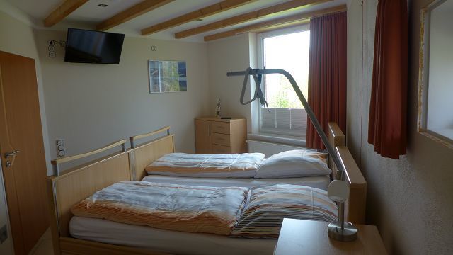 Schlafzimmer EG mit TV und mobilen Pflegebetten (als Einzel- und Doppelzimmer nutzbar)